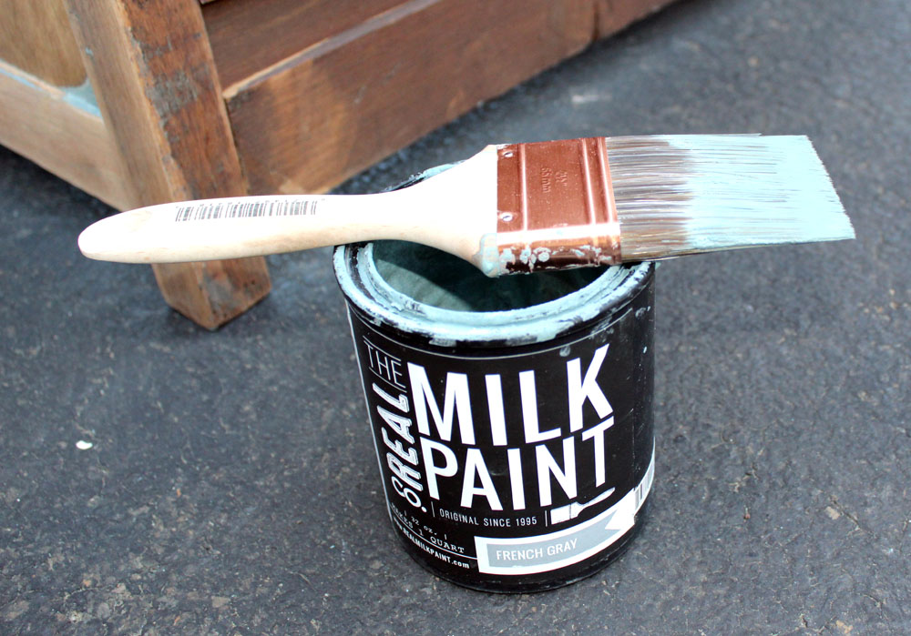 Using a good bristle brush to milk paint an old dresser