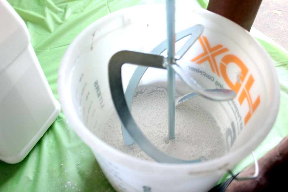 Mixing milk paint in a bucket with a drill attachment