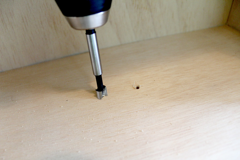 Drilling away some of the wood so that the screws will go through